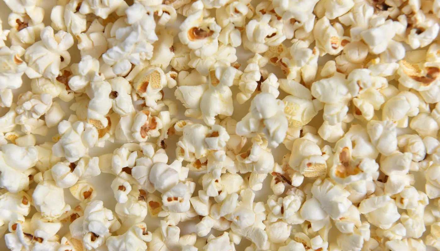 Freshly popped popcorn filling the frame, with a few unpopped kernels