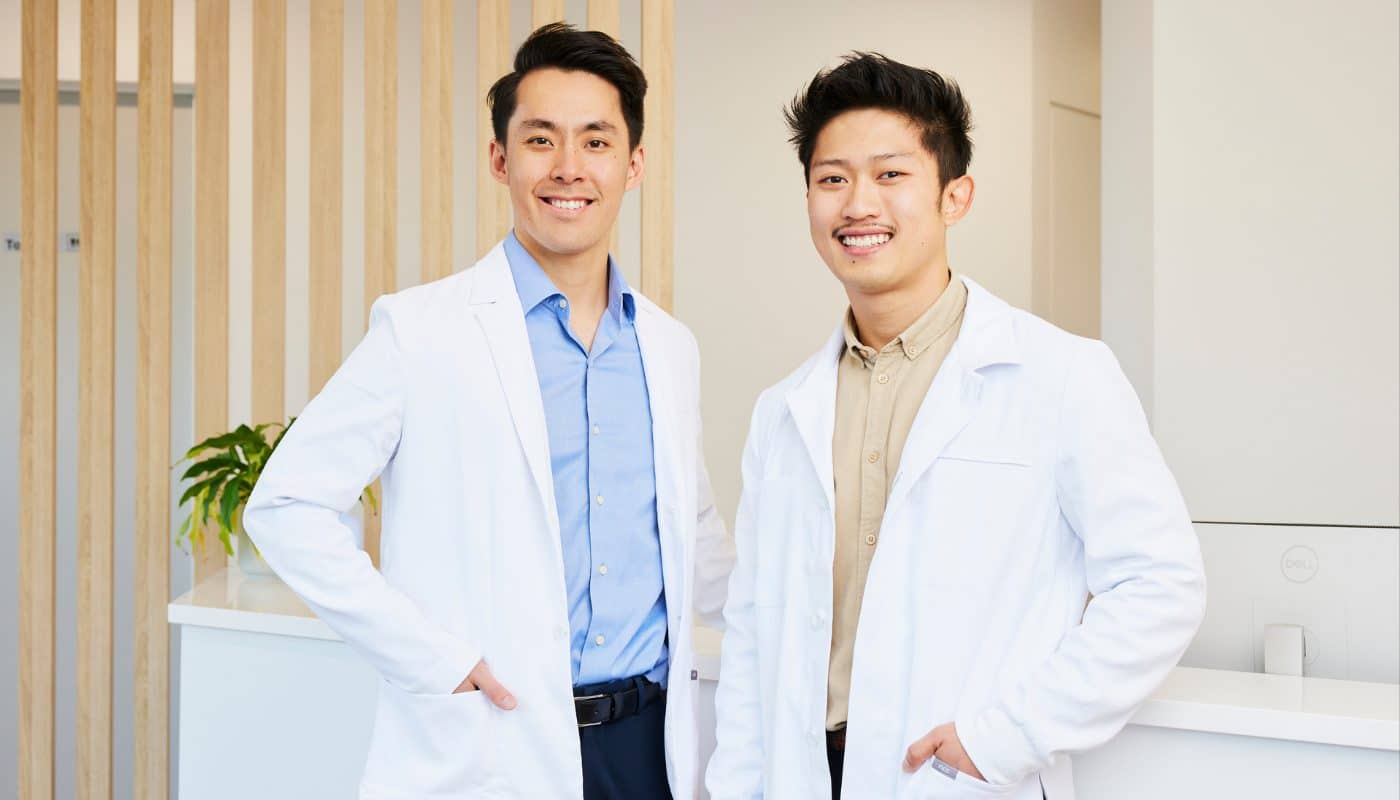Two Dove Dental dentists in white coats standing at the Waurn Ponds clinic reception