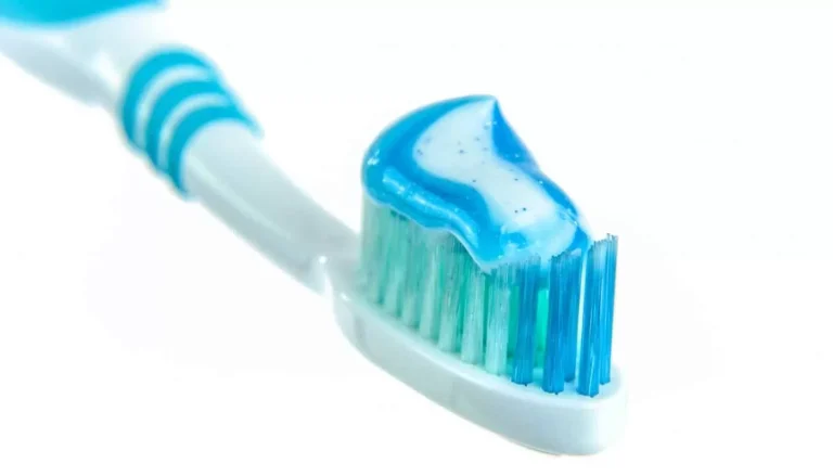 Close-up of a toothbrush loaded with blue fluoride toothpaste