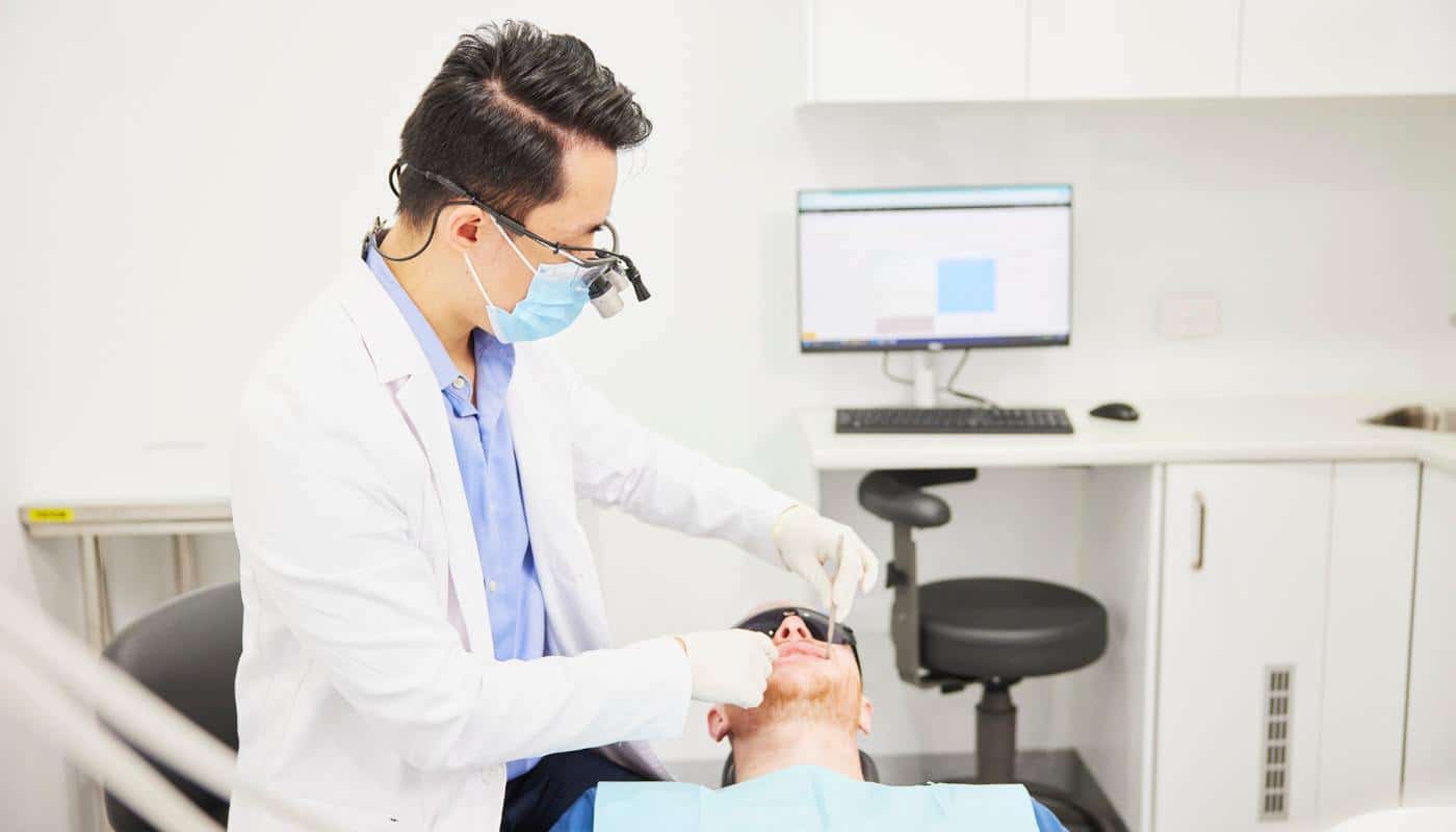 A dentist performing a professional clean on a patient in the treatment room