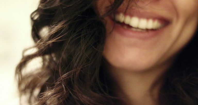 Close-up of a woman laughing, her smile filling the frame