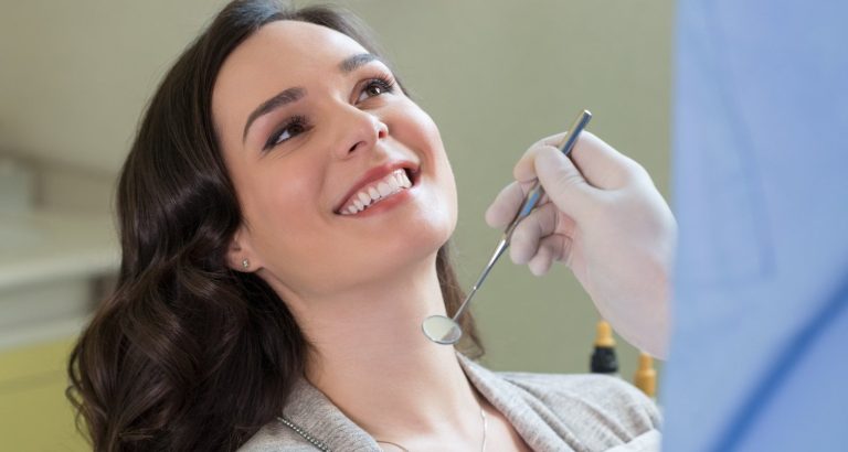 A smiling patient in the dental chair during an examination